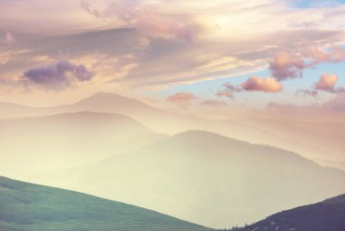 Gün doğumunda sisli dağ silueti