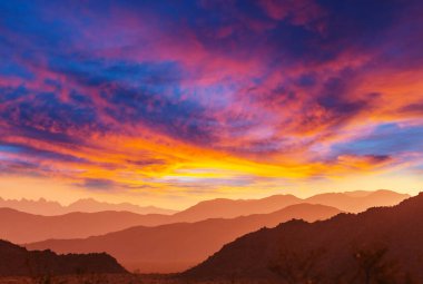 Gün doğumunda sisli dağ silueti