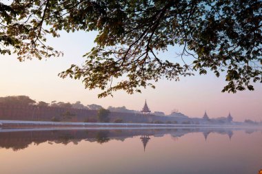 Mandalay Sarayı 'nın Mandalay, Burma' daki (Myanmar) kanalı gündoğumunda çevreleyen kanala yansıyan kadim kahverengi tuğla saray duvarı.