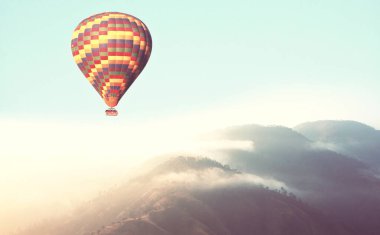 Yeşil tepelerin üzerinde balonlar. Doğal arka planda seyahat et.