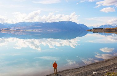 Bir adam sakin gölün yanında dinleniyor. Rahatlama tatili
