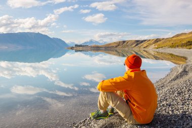 Bir adam sakin gölün yanında dinleniyor. Rahatlama tatili