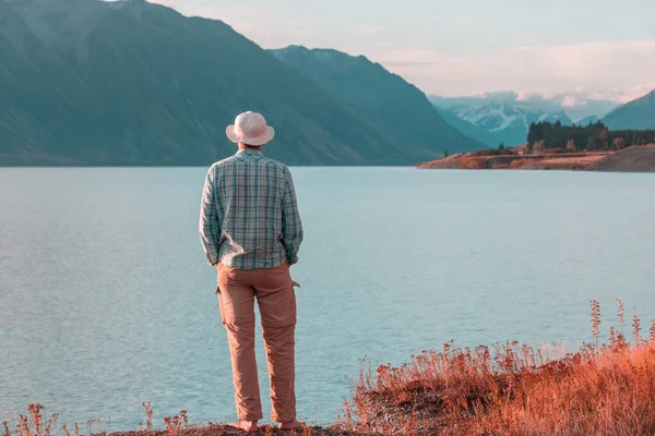 Bir adam sakin gölün yanında dinleniyor. Rahatlama tatili
