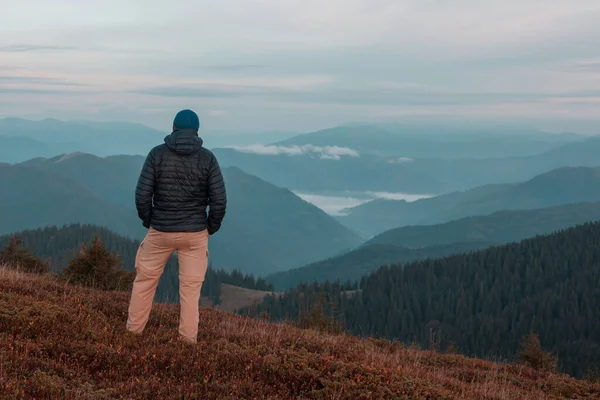 Gün doğumunda dağlarda dinlenen adam