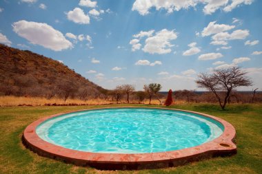 Adam Afrika kampında yüzme havuzuna atlıyor.