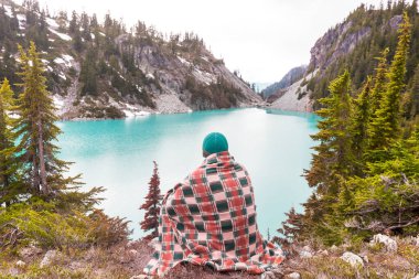 Bir adam sakin gölün yanında dinleniyor. Rahatlama tatili