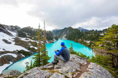 Bir adam sakin gölün yanında dinleniyor. Rahatlama tatili