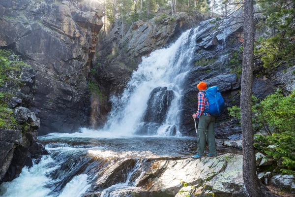 Homem Com Uma Mochila Olhando Para Uma Cachoeira Nas Montanhas — Fotografia de Stock