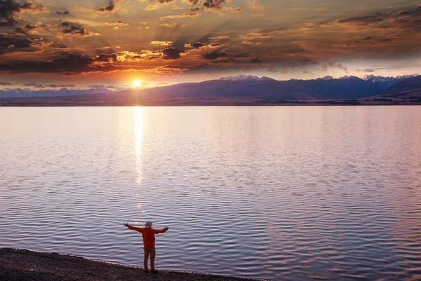 A man is resting at ease by the calm lake. Relaxation vacation