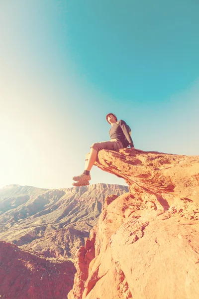 Man sitting  on  cliff — Stock Photo, Image