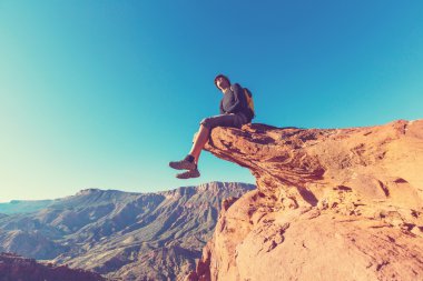 Cliff üzerinde oturan adam