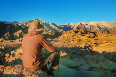 Erkekler, Alabama tepelerinde güneş doğarken, Kaliforniya 'da olağandışı taş oluşumlarını gözden geçirirler.