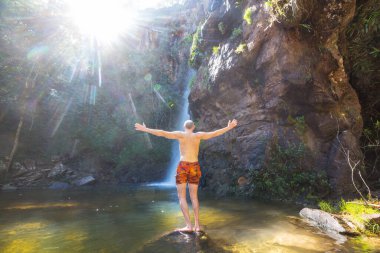Brezilya ormanlarında şelalenin yanındaki turist