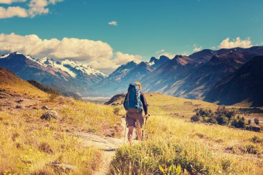 Uzun yürüyüşe çıkan kimse sırt çantasında Patagonya Dağları ile