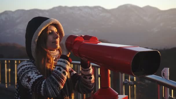 Turista mirando a la ciudad a través de prismáticos operados con monedas al atardecer, tiro medio — Vídeo de stock