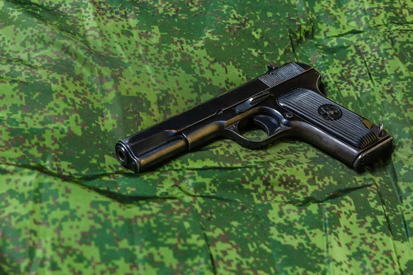 Pistola semiautomática sobre fondo de camuflaje pixel — Foto de Stock