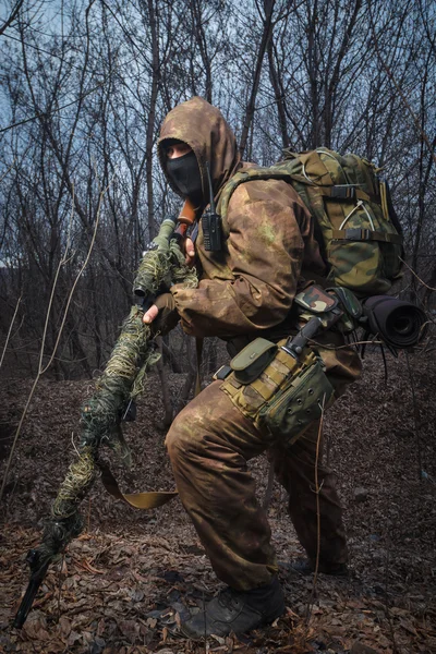 Sniper portant un costume de camouflage avec une promenade de fusil dans les bois — Photo