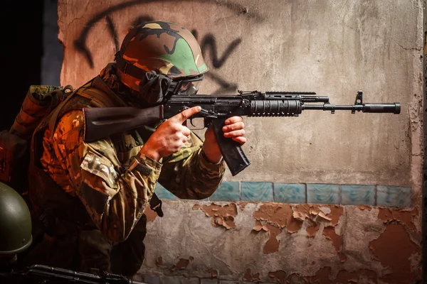 Soldat med den ryska kulsprutan i övergiven byggnad — Stockfoto