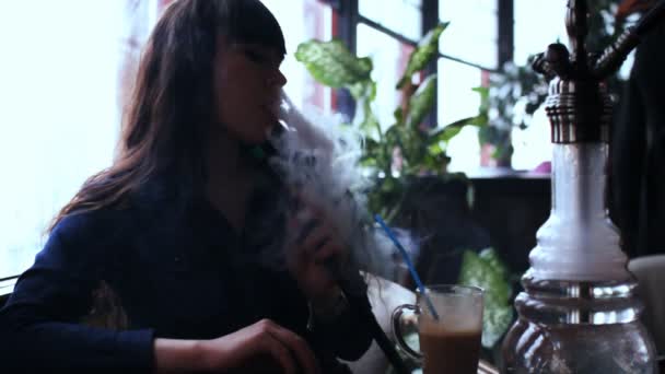 Krásná mladá žena vdechnutím vodní dýmka. dívka kouření shisha v kavárně. Silueta — Stock video