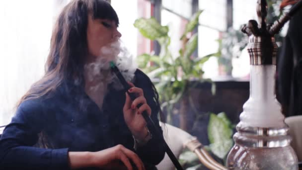 Bella giovane donna che inspira narghilè. Ragazza che fuma Shisha nel caffè . — Video Stock