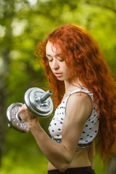 Rossa ragazza esercizio con manubri a foresta — Foto Stock