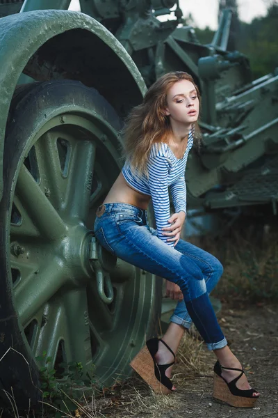 Young sexy model posing near old artillery — Stock Photo, Image