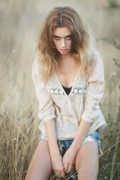 Joven modelo sexy posando en un campo al atardecer — Foto de Stock