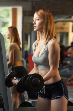 Genç güçlü kız yapmak egzersizleri dumbbells ile