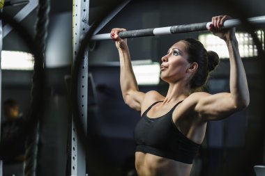 Güçlü çekici kadın Crossfit eğitmen pull ups egzersiz sırasında