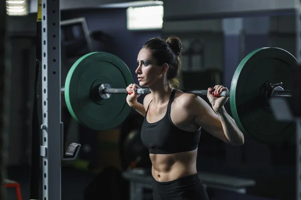 Potente mujer muscular atractiva CrossFit entrenador hacer ejercicio con barra — Foto de Stock