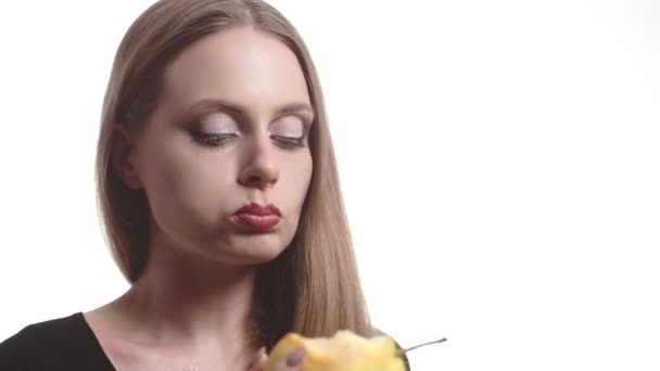 Beautiful young woman with red lips eating pear — Stock Video