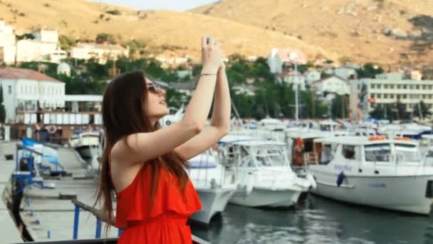 Usmívající se dívka vyfotit s smartphone fotoaparát venku — Stock video