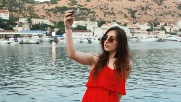 Usmívající se dívka vyfotit s smartphone fotoaparát venku — Stock video