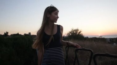 Günbatımı üzerinde yürüyen genç kadın