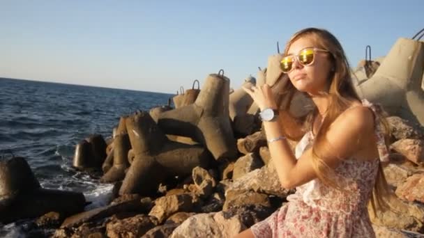 Atraente sorrindo mulher escovando seu cabelo na praia — Vídeo de Stock