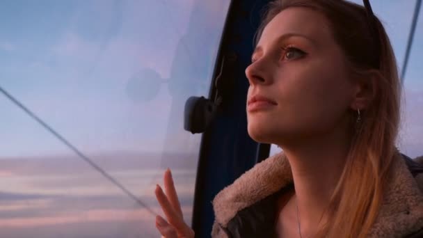 Ταξίδια: όμορφη νεαρή γυναίκα τουρίστρια κοιτάζοντας μέσα από το γυαλί στην καμπίνα με σχοινιά hotaka στο ηλιοβασίλεμα. Κοντινό πλάνο, αργή κίνηση 60 fps, φορητή. — Αρχείο Βίντεο