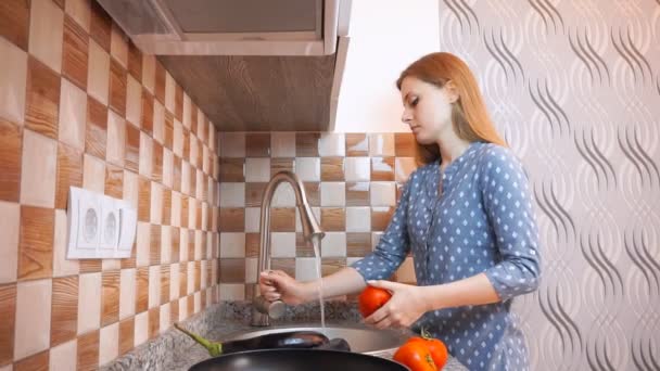 Здоровый образ жизни: красивая женщина небрежно готовит, моет овощи на кухне. Широкий выстрел, ручной, замедленная съемка 60 кадров в секунду . — стоковое видео