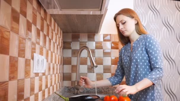 Estilo de vida saludable: hermosa mujer cocinando casualmente, lavando verduras en la cocina. Tiro ancho, de mano, cámara lenta 60 fps . — Vídeo de stock