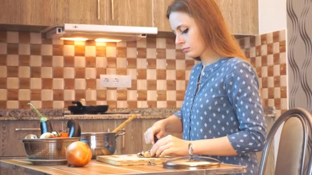 Здоровый образ жизни: красивая женщина небрежно готовит, режет овощи на кухне. Средний выстрел, ручной, замедленная съемка 60 кадров в секунду . — стоковое видео