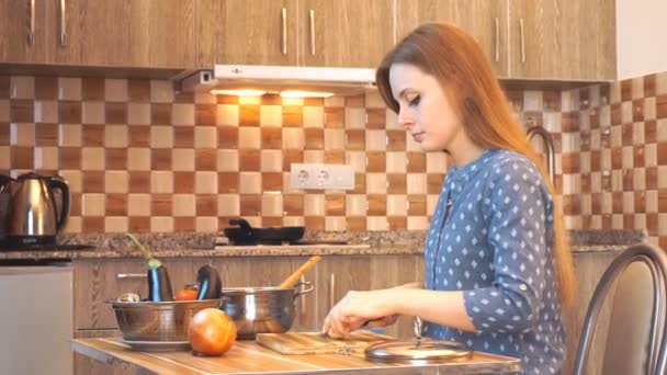 Estilo de vida saludable: hermosa mujer cocinando casualmente, cortando verduras en la cocina. Tiro medio, de mano, cámara lenta 60 fps . — Vídeos de Stock