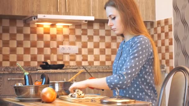 Здоровый образ жизни: красивая женщина небрежно готовит, режет овощи на кухне. Средний выстрел, ручной, замедленная съемка 60 кадров в секунду . — стоковое видео