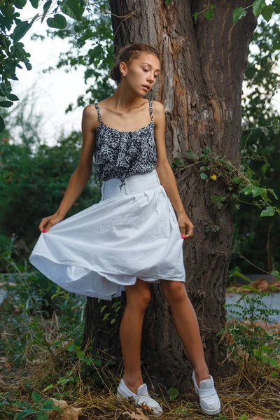 Retrato de moda sesión de hermosa chica adolescente posando cerca del árbol — Foto de Stock