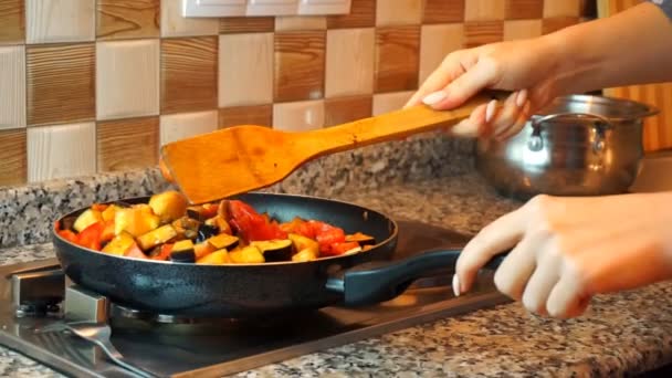 Υγιής τρόπος ζωής: όμορφη γυναίκα άνετα μαγειρεύοντας, ανακατέψτε, σιγοβράζουμε το λαχανικό σε τηγάνι στην κουζίνα. Κοντινό πλάνο, φορητή, αργή κίνηση 60 fps. — Αρχείο Βίντεο