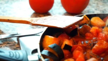 Sağlıklı gıda yaşam tarzı: güzel kadın rahat yemek, karıştırın, mutfakta tavada sebze kaynatın. Yakın çekim, el, yavaş çekim 60 fps.