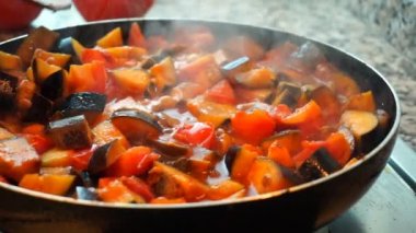 Sağlıklı gıda yaşam tarzı: güzel kadın rahat yemek, karıştırın, mutfakta tavada sebze kaynatın. Yakın çekim, el, yavaş çekim 60 fps.