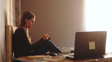 Yaşam tarzı: genç güzel kız serbest sanatçı tasarımcı çizim ve gün batımı sırasında evde kraftpaper üzerinde çizim. Orta çekim, statik, yavaş çekim 60 fps.