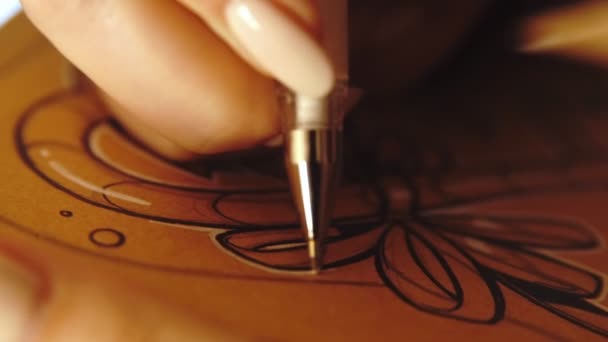 Mode de vie : jeune belle fille freelance artiste designer croquis et dessin photo de Noël sur papier kraftpaper pendant le coucher du soleil, travaillant de la maison. Gros plan, à la main, au ralenti 60 ips . — Video