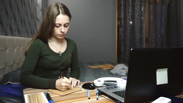 Lifestyle: jong mooi meisje freelance kunstenaar ontwerper schetsen en tekenen op Kraft papier 's avonds nacht, werken vanuit huis. Wide shot, handheld, Slow Motion 60 fps. — Stockvideo