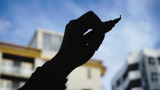 Lifestyle: mooie jonge vrouw het tekenen van wiskundige zakelijke grafieken op het glas met blauwe hemel, wolkenkrabber op achtergrond. Silhouet. Close-up shot, handheld, Slow Motion 60 fps. — Stockvideo