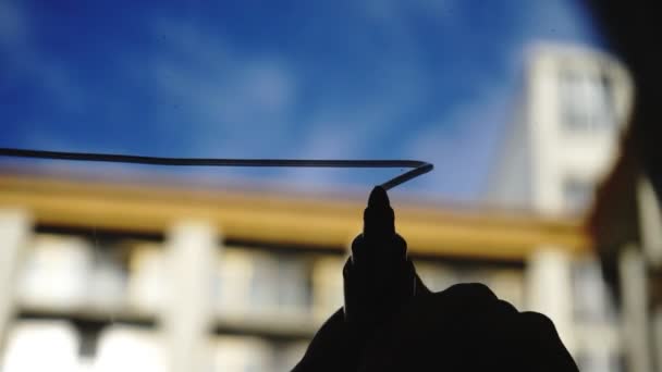 Lifestyle: schöne junge Frau, die Mathe-Business-Graphen auf das Glas mit blauem Himmel zeichnet, Wolkenkratzer im Hintergrund. Silhouette. Südpfote. Nahaufnahme, Handheld. — Stockvideo